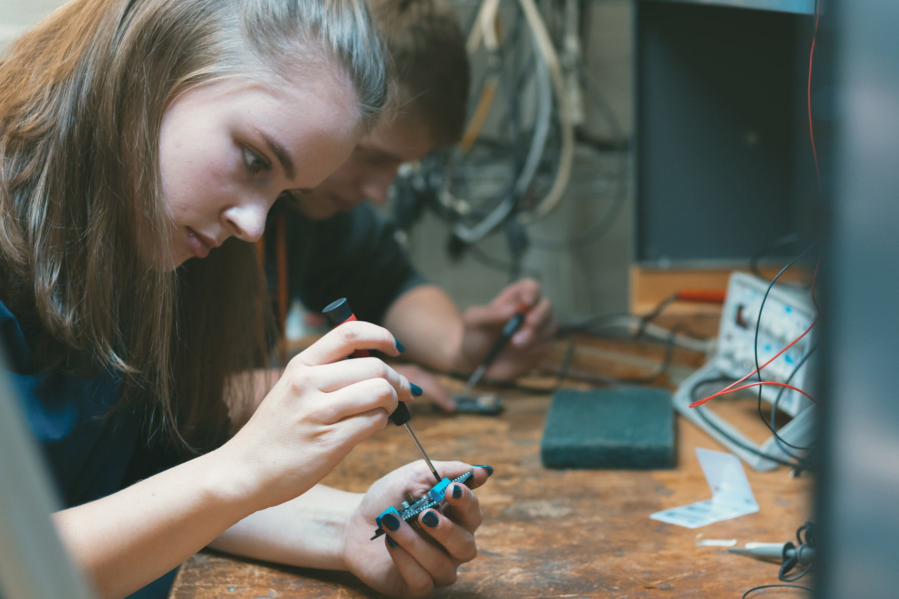 Zwei Jugendliche, eine Mädchen und ein Junge, bearbeiten Elektroden